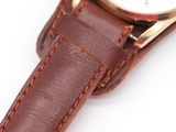 a close up of a watch on a white surface