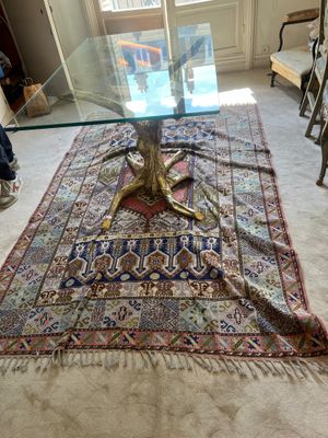 un tapis posé au sol, à côté d'une table en verre