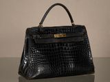 sac à main en cuir d'alligator noir avec des finitions dorées