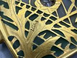 a close up of a gold clock with a face on it