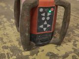 a picture of a red and black laser level on the floor