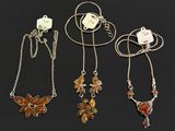 a group of four necklaces with butterfly charms on them
