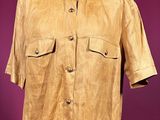 a brown shirt on a mannequin stand against a purple wall