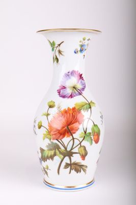 un vase blanc sur lequel sont peintes des fleurs colorées