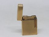 a gold lighter that is sitting on a white surface