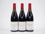 trois bouteilles de vin sont posées côte à côte sur une surface blanche