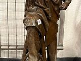 statue en bronze représentant un homme avec un chien, posée sur un socle