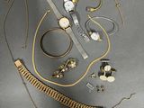 Plusieurs bijoux sont disposés sur une surface grise