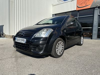 la petite voiture noire est garée devant un bâtiment