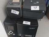 many different printers on a shelf in a room
