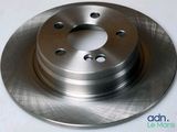 a close up of a brake disc on a white surface