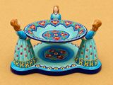 Deux figurines représentant deux femmes en robe bleue sont posées sur une table