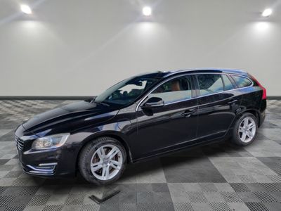 une Volvo break noire garée sur un sol en carrelage à damier