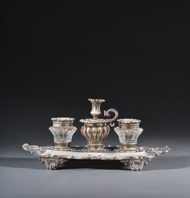 a silver plate with three cups and a saucer on a tray