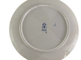 a white plate with blue writing on it on a white surface