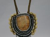 a close up of a necklace with beads and beads on a stand