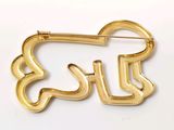 an image of a gold brooch with a dog on it