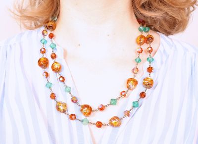 Collier fantaisie orné de perles alternées orange et bleues.