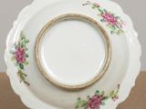 a white plate with pink flowers on it sitting on a table