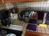 un plan de travail de cuisine équipé d'un micro-ondes, d'un grille-pain, d'une cafetière et d'autres ustensiles de cuisine