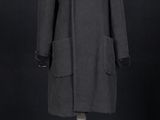une image d'un manteau noir sur un support de mannequin
