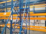 an industrial warehouse racking system with multiple levels and ladders