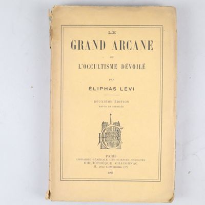 un vieux livre posé sur une table à côté d'un mur blanc