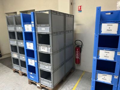 de nombreuses caisses bleues portant des étiquettes dans un entrepôt