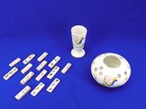 un vase blanc, une tasse et un jeu de dominos sur fond bleu
