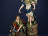 an image of a statue of an angel and a man kneeling on a rock