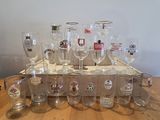 bottles and glasses are lined up on a wooden tray on a table