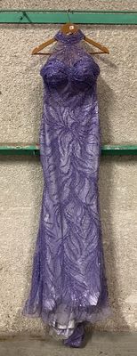 a purple dress hanging on a hanger on a wall