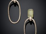 a pair of gold and green stone earrings on a black background