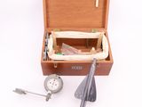 une boîte en bois contenant des outils, posée sur une surface blanche