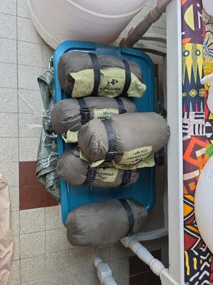 des toilettes avec un tas de sacs posés sur le réservoir