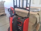 a red fork lift truck parked in a warehouse