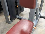 a close up of a red seat on a machine in a gym