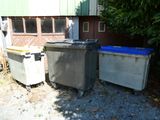 deux poubelles placées l'une à côté de l'autre devant un immeuble
