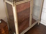 a cabinet with a glass door in the corner of a room