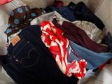a pile of clothes on a bed with a polka dot blanket