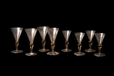 six verres à vin sont alignés sur un fond noir