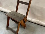 a wooden chair sitting in front of a white wall