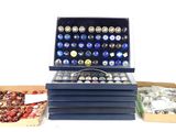 several boxes of assorted buttons are sitting on a white surface