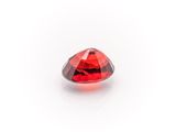 a close up of a red diamond on a white surface