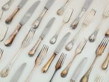 une multitude de couverts sur une table, avec des fourchettes et des couteaux