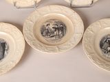 five plates with pictures of people on them on a table