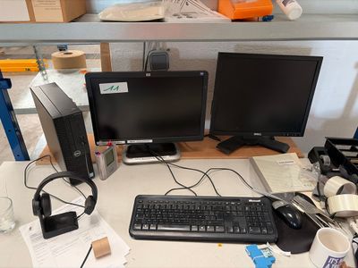 un bureau sur lequel se trouvent un clavier, un écran, une souris et d'autres objets
