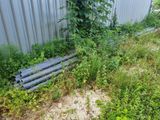 a bunch of pipes in the grass next to a building