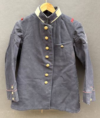 un vieux manteau militaire est suspendu à un cintre