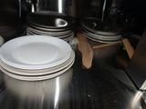 several white plates stacked on top of each other in a kitchen